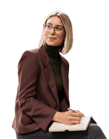 Eine Frau mit Brille sitzt und schreibt in Notizbuch.