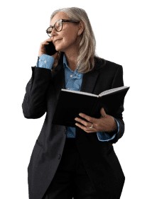 Eine ältere Frau mit Brille telefoniert und hält ein Buch.